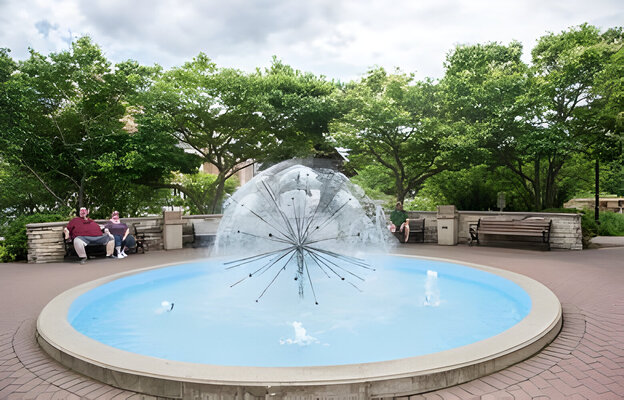 Tourists and flowing water fountain on the riverwalk in downtown Naperville, Illinois