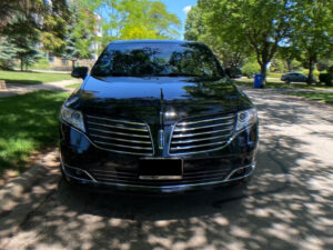 A black luxury corporate sedan standing side of the road